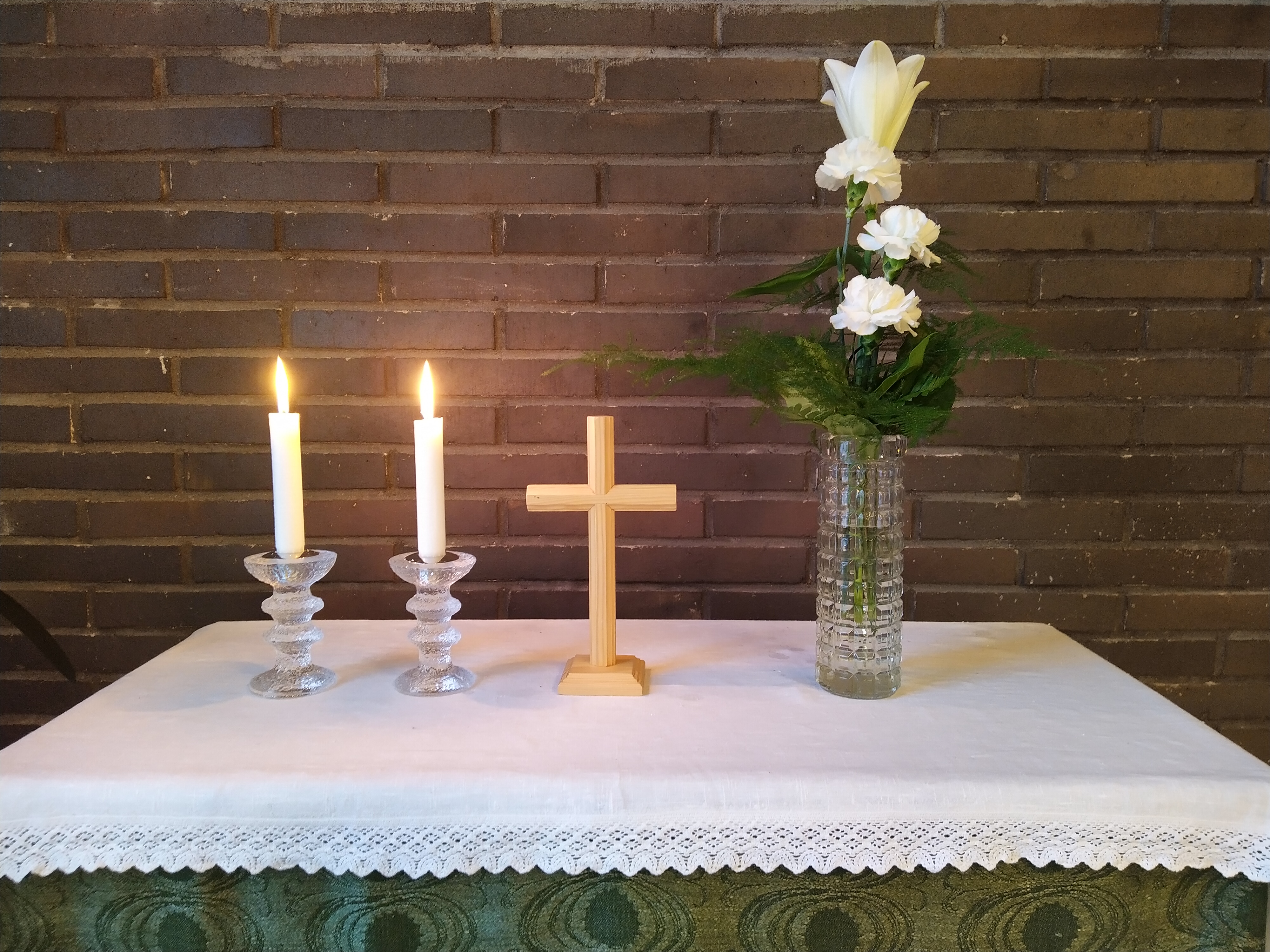 seurakuntatalon alttari, vihreä ja kaksi kynttilää