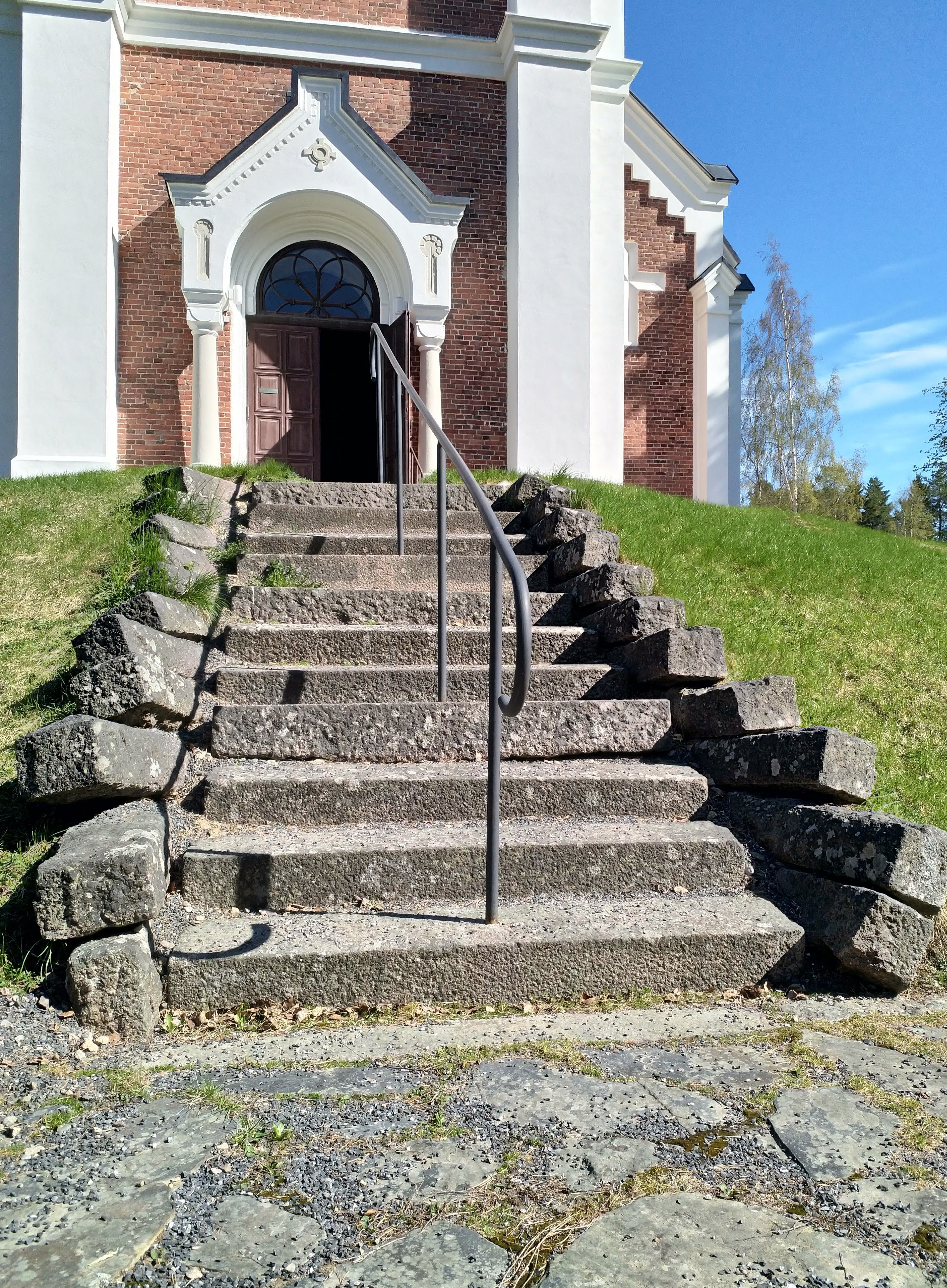 kuva kirkon pääoven edessä olevilta kiviportailta, jotka nousevat sankarihaudoilta