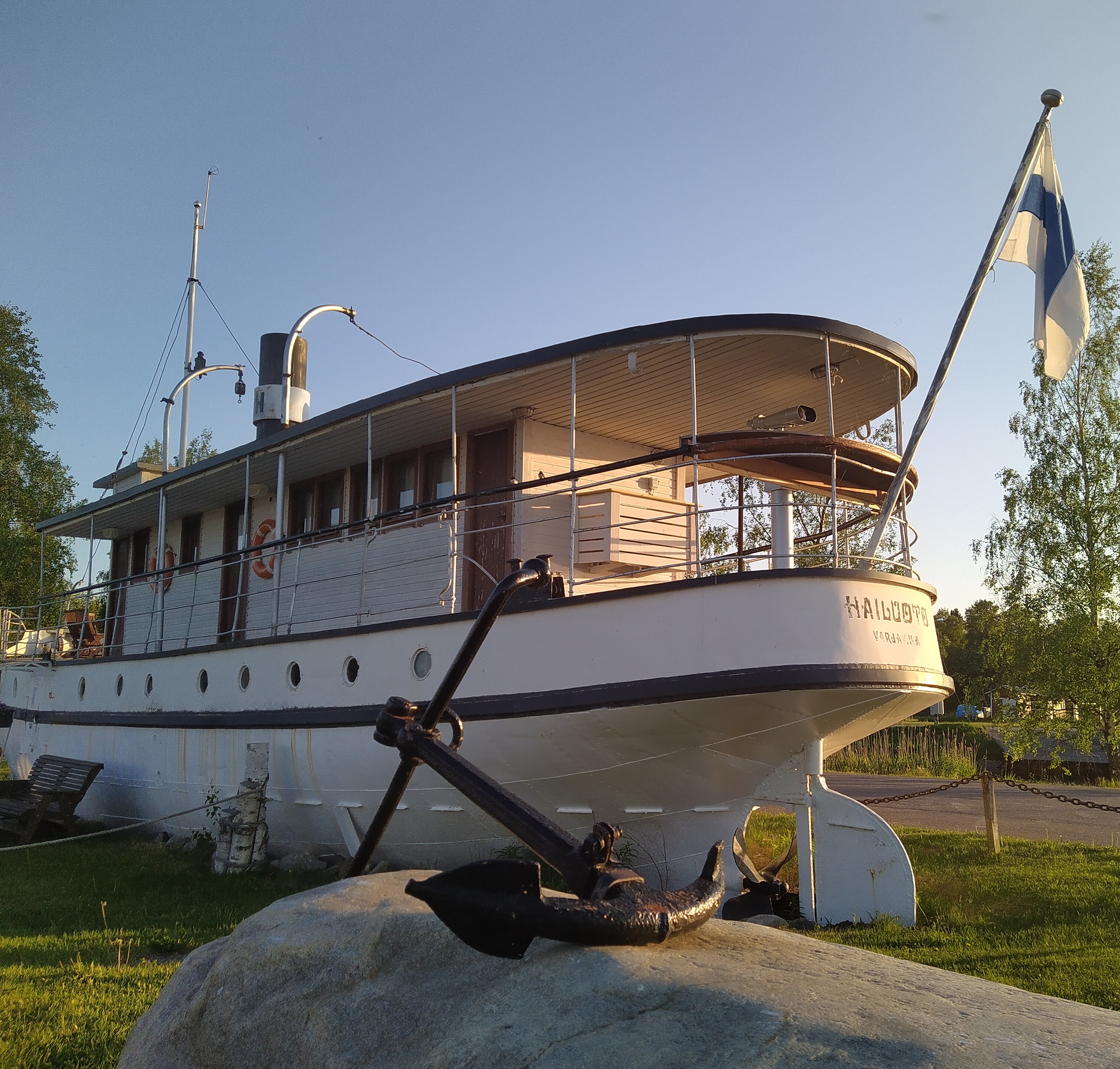 Lumijoen Varjakan Hailuotolaiva -kahvila, edessä ankkuri ja Suomen lippu