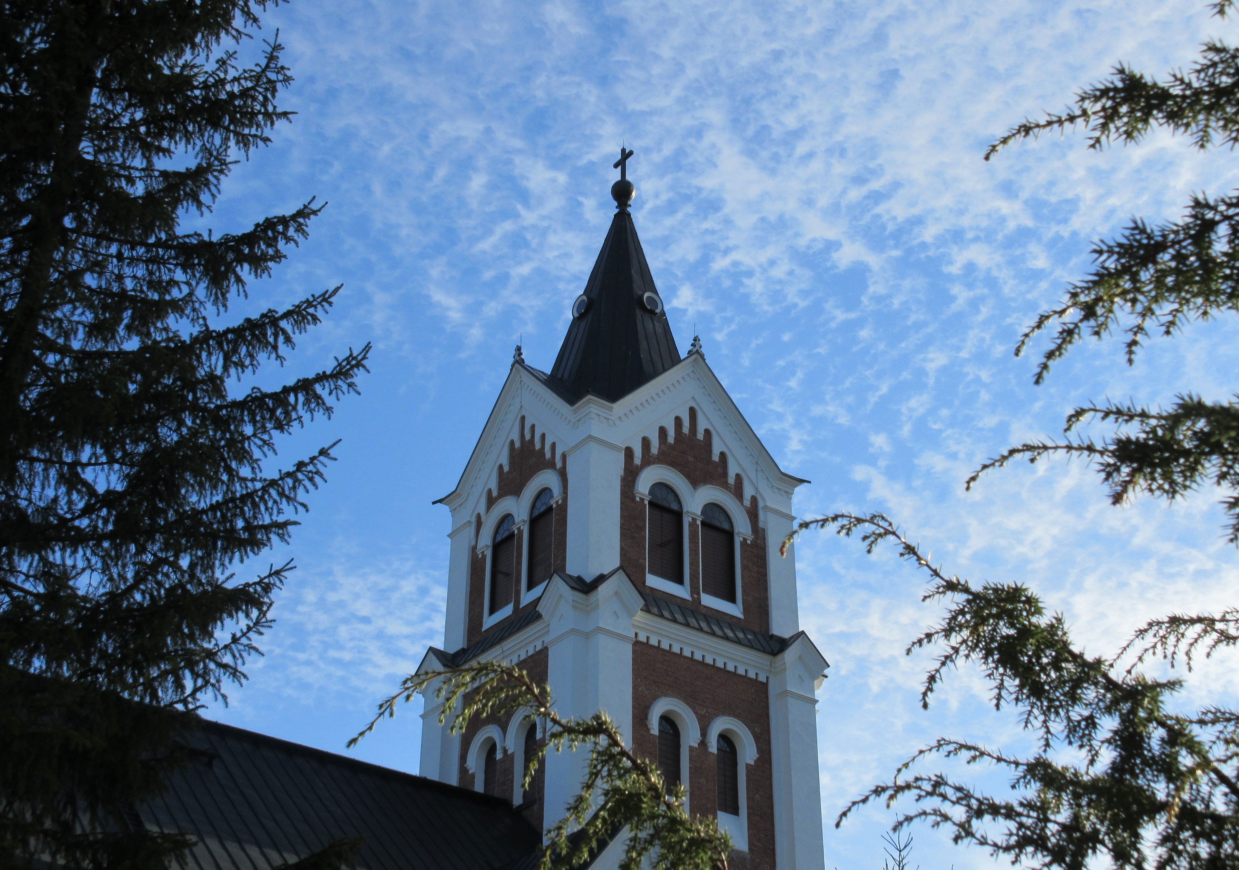 Lumijoen kirkon torni ja väreileviä pilviä